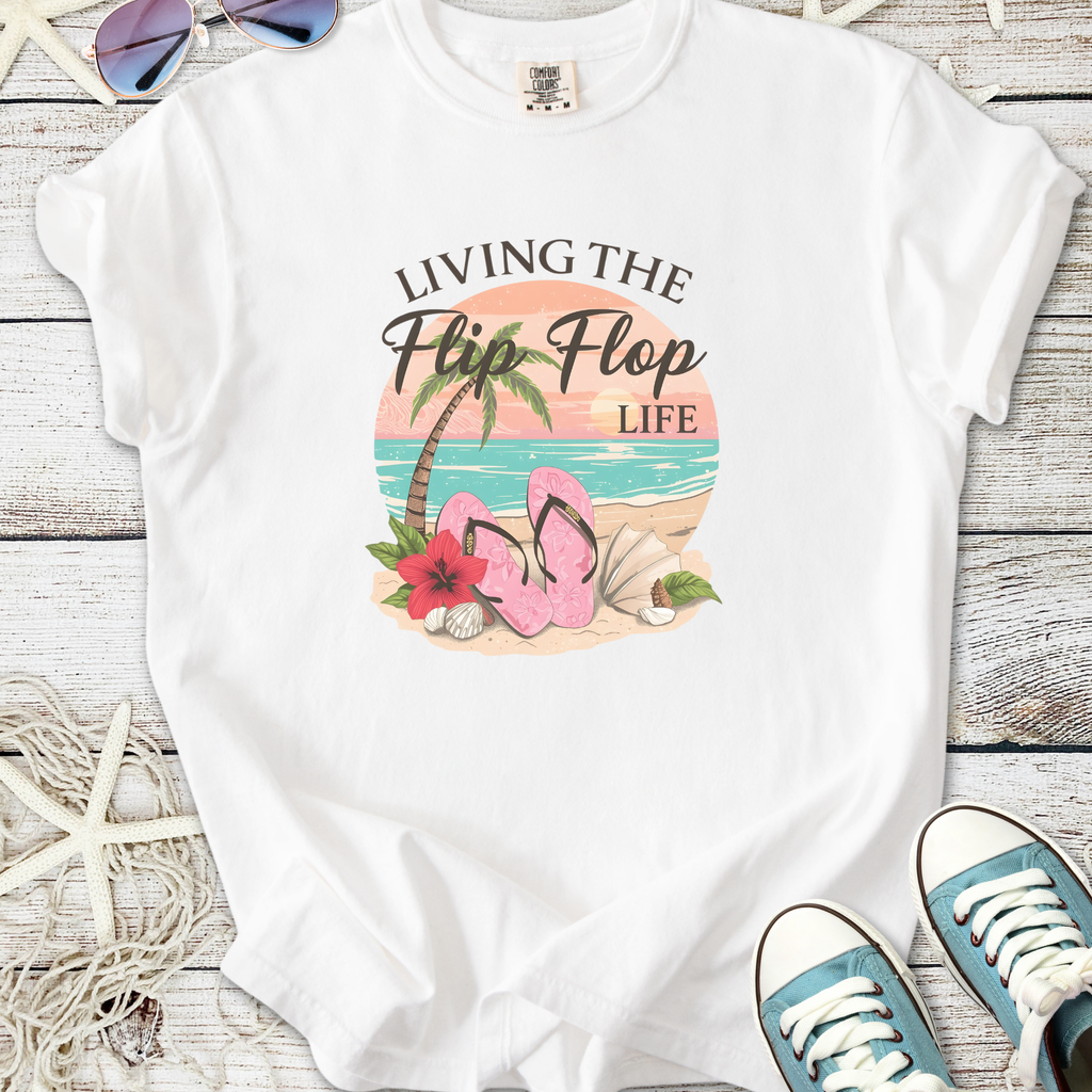 White t-shirt with 'Living the Flip Flop Life' graphic, featuring pink flip flops, beach theme, and casual style.