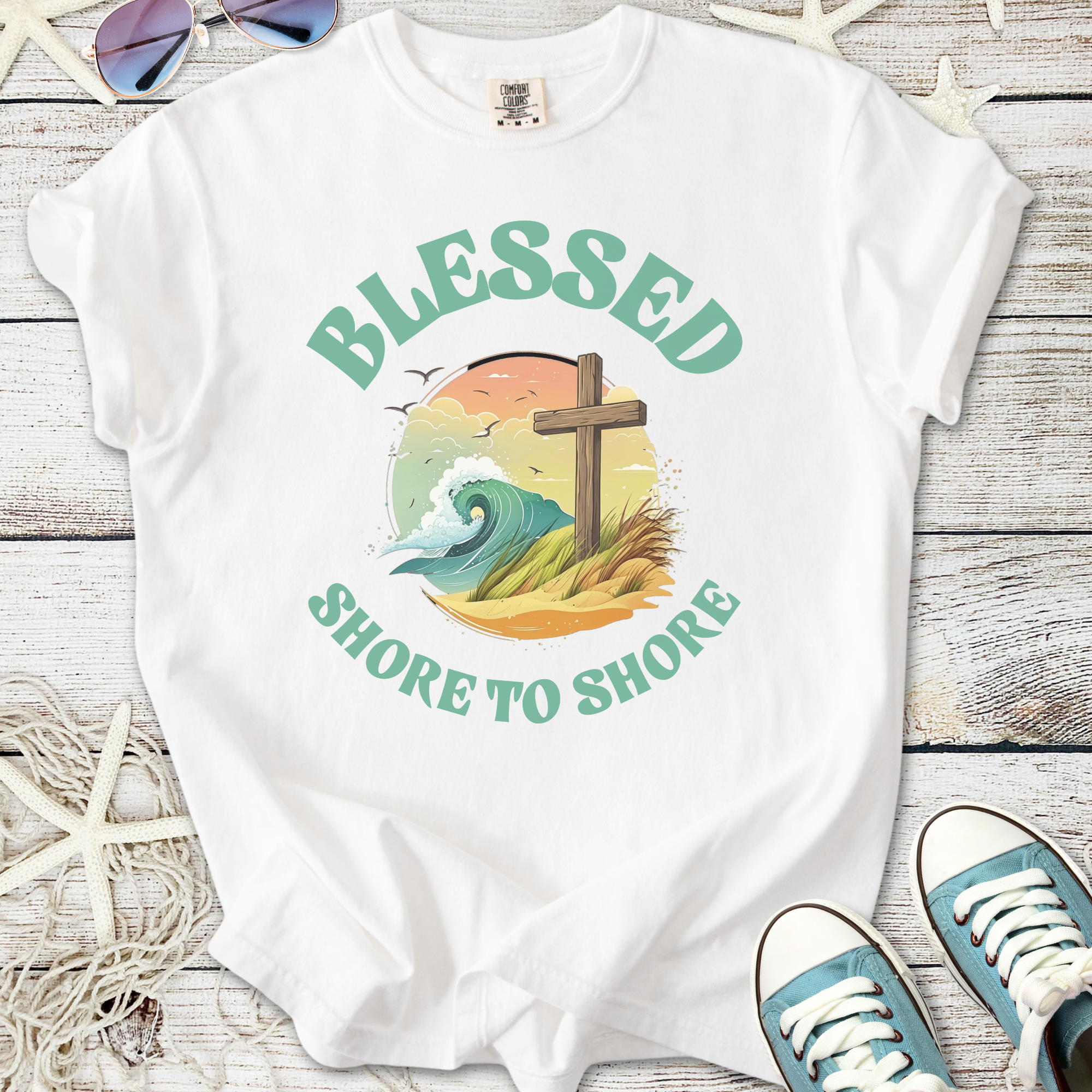 White graphic tee with 'Blessed Shore to Shore', featuring ocean wave and cross design.