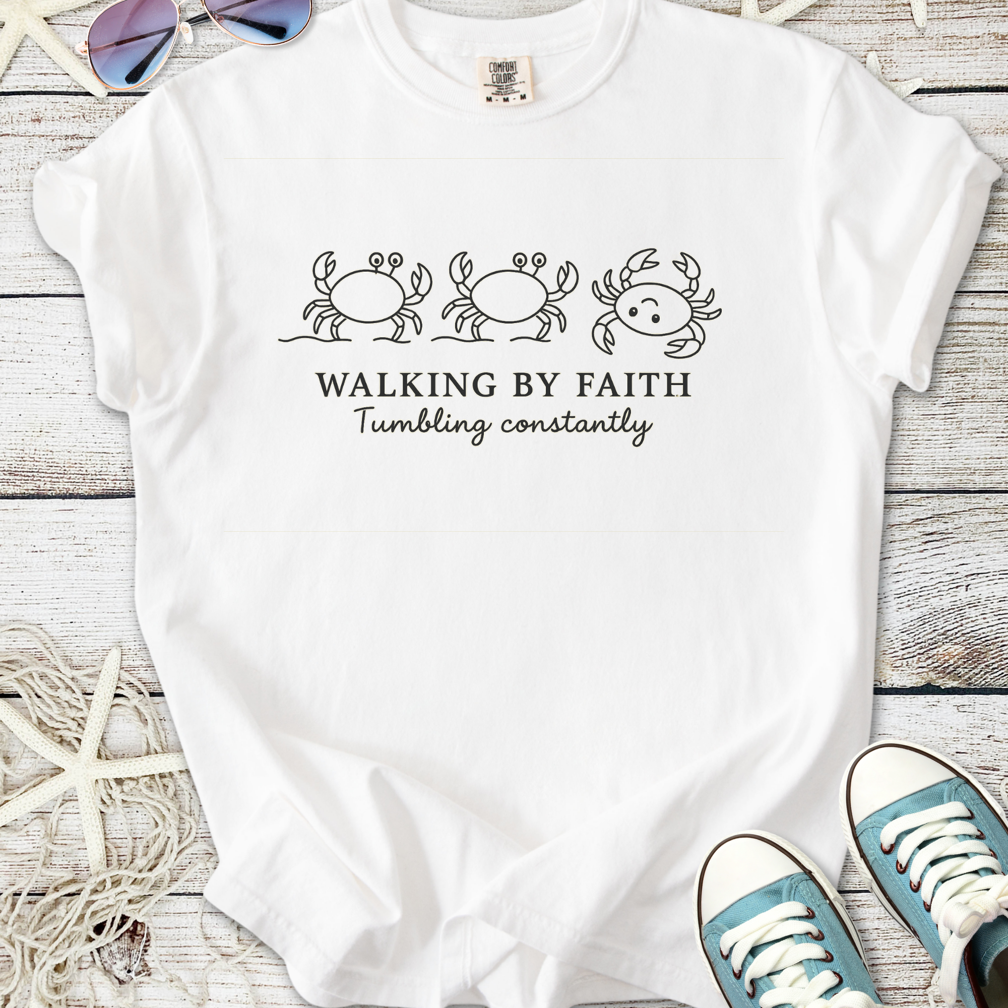 White t-shirt with crab illustrations and 'Walking By Faith, Tumbling Constantly' text design.