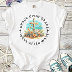 White t-shirt featuring 'Grace Upon Grace' design with floral graphics and a cross.