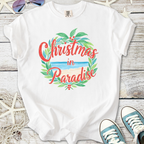 White t-shirt with 'Christmas in Paradise' graphic, featuring tropical leaves and beach design.