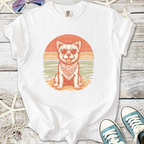 White t-shirt featuring a dog in sunglasses and a bandana, beach sunset graphic design.