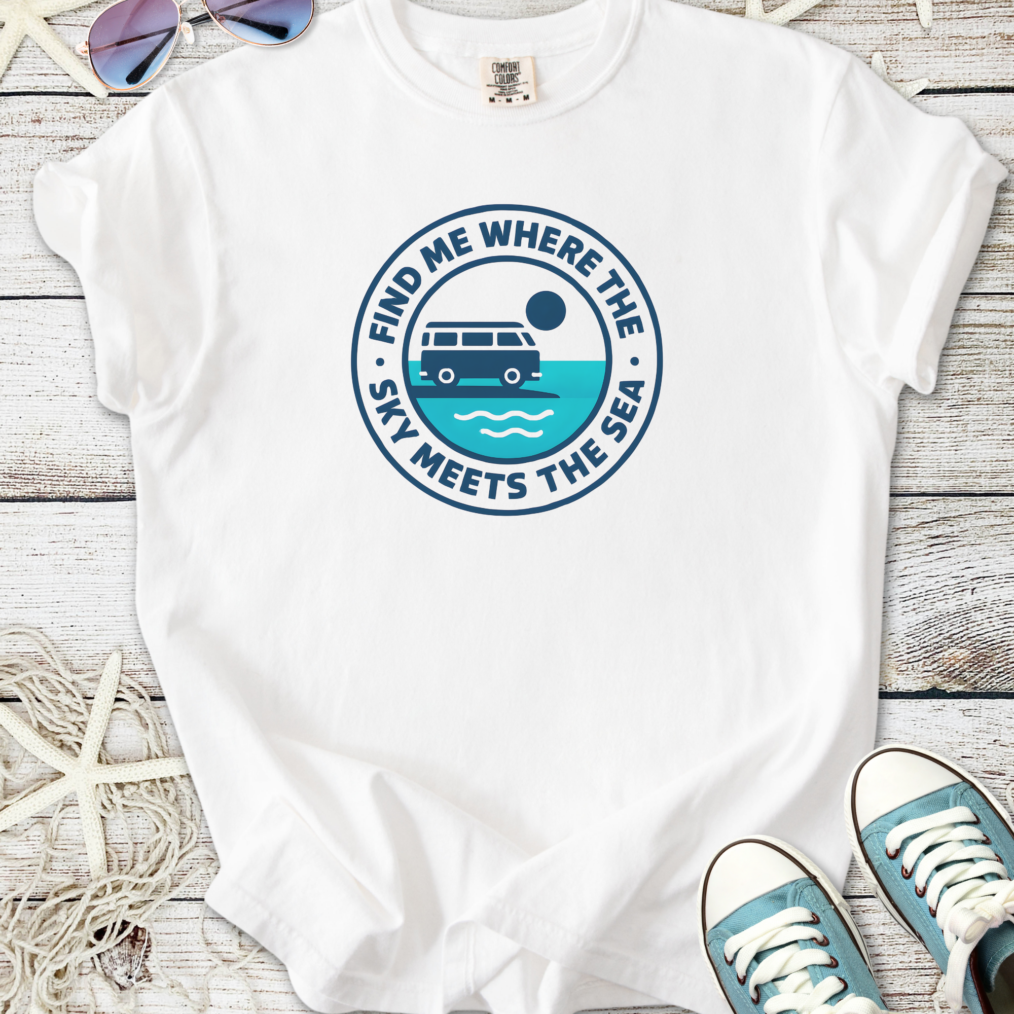 White t-shirt with 'Find Me Where the Sky Meets the Sea' graphic, featuring a camper van and ocean design.