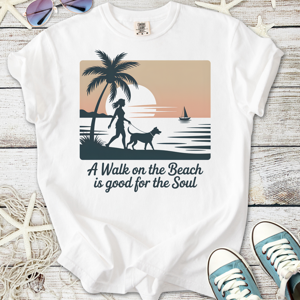 White t-shirt with beach-themed graphic, featuring a woman walking a dog and sunset design.