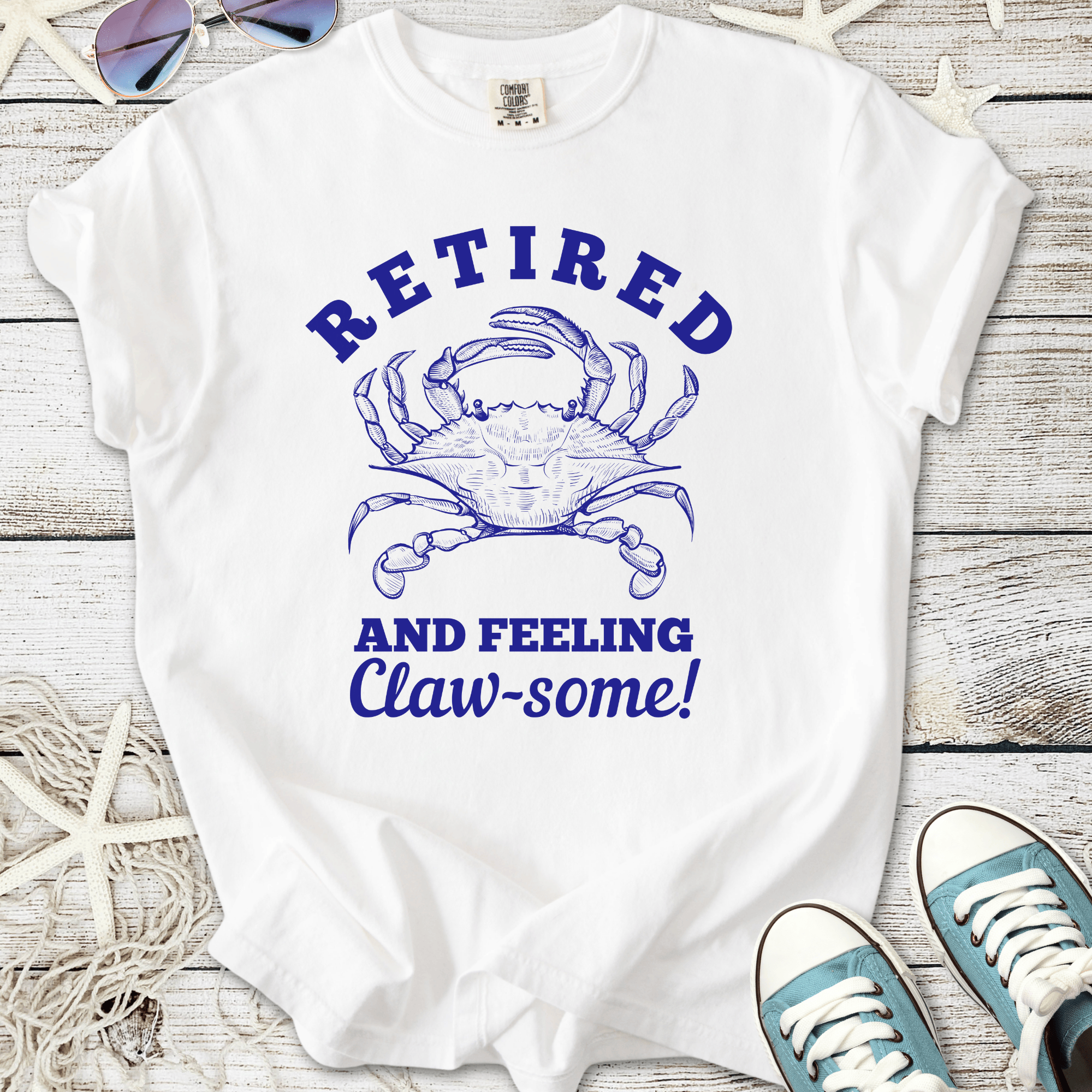White t-shirt with blue crab graphic and text 'Retired and Feeling Claw-some!', perfect for retirees.