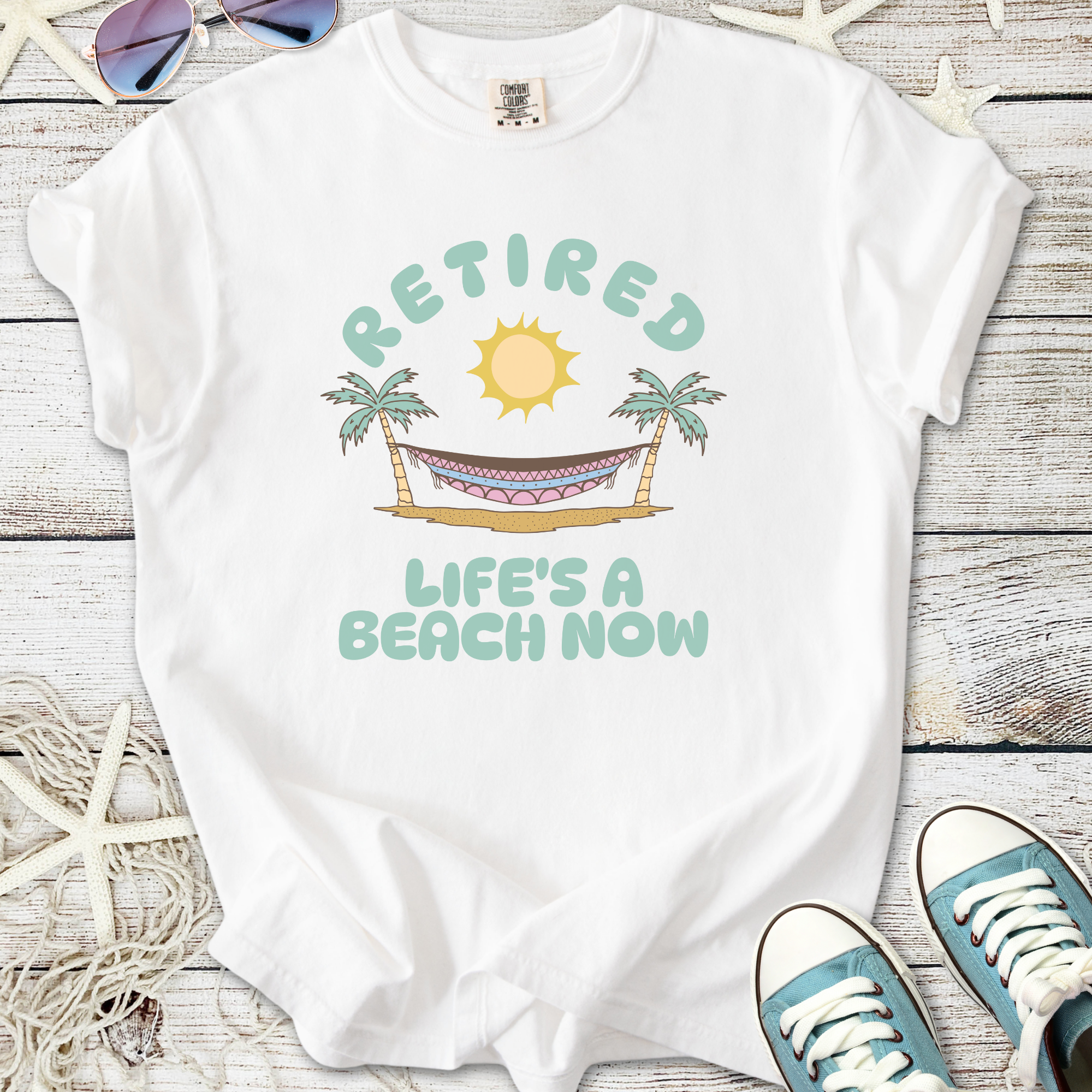 White cotton t-shirt with 'Retired, Life's a Beach Now' graphic featuring sun and palm trees.