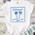 White cotton t-shirt with blue palm tree graphic and 'Retirement sea more stress less' slogan.