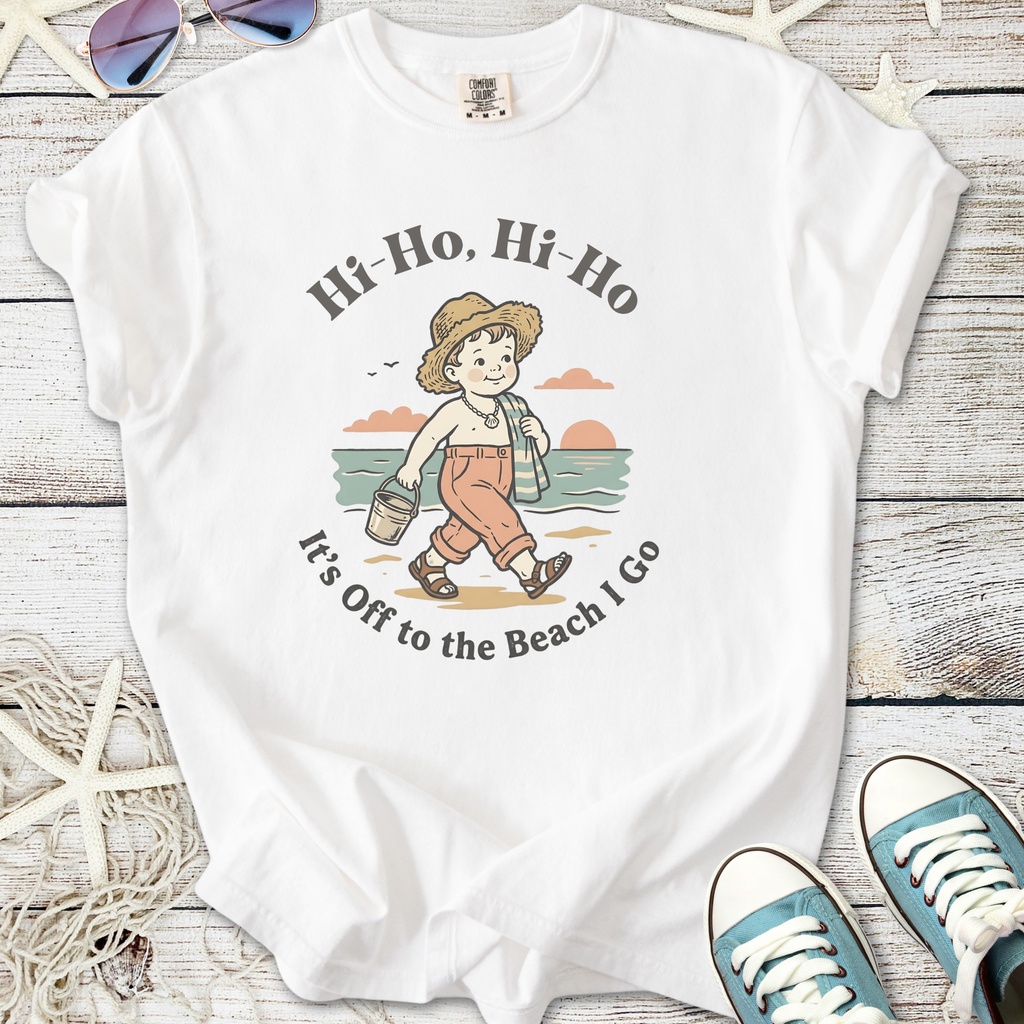 White graphic tee featuring a retro beach design with a child and the phrase 'It's Off to the Beach I Go'.