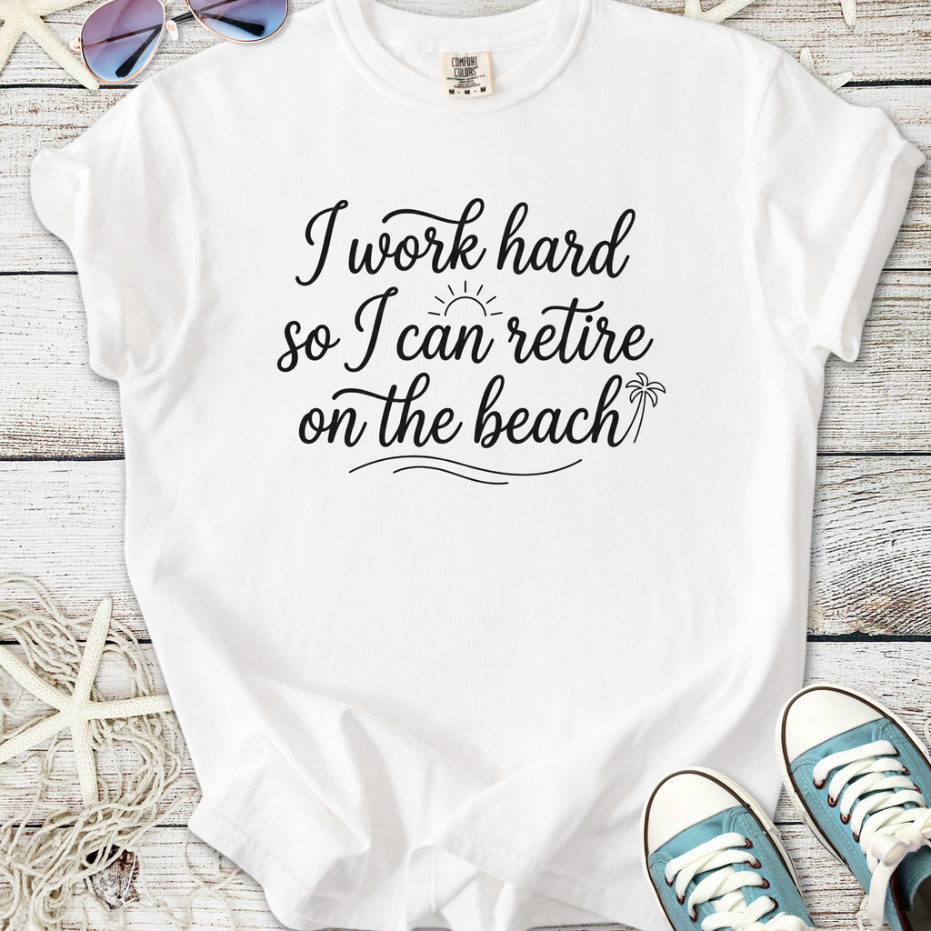 White cotton t-shirt with 'I work hard so I can retire on the beach' print, perfect for casual summer wear.