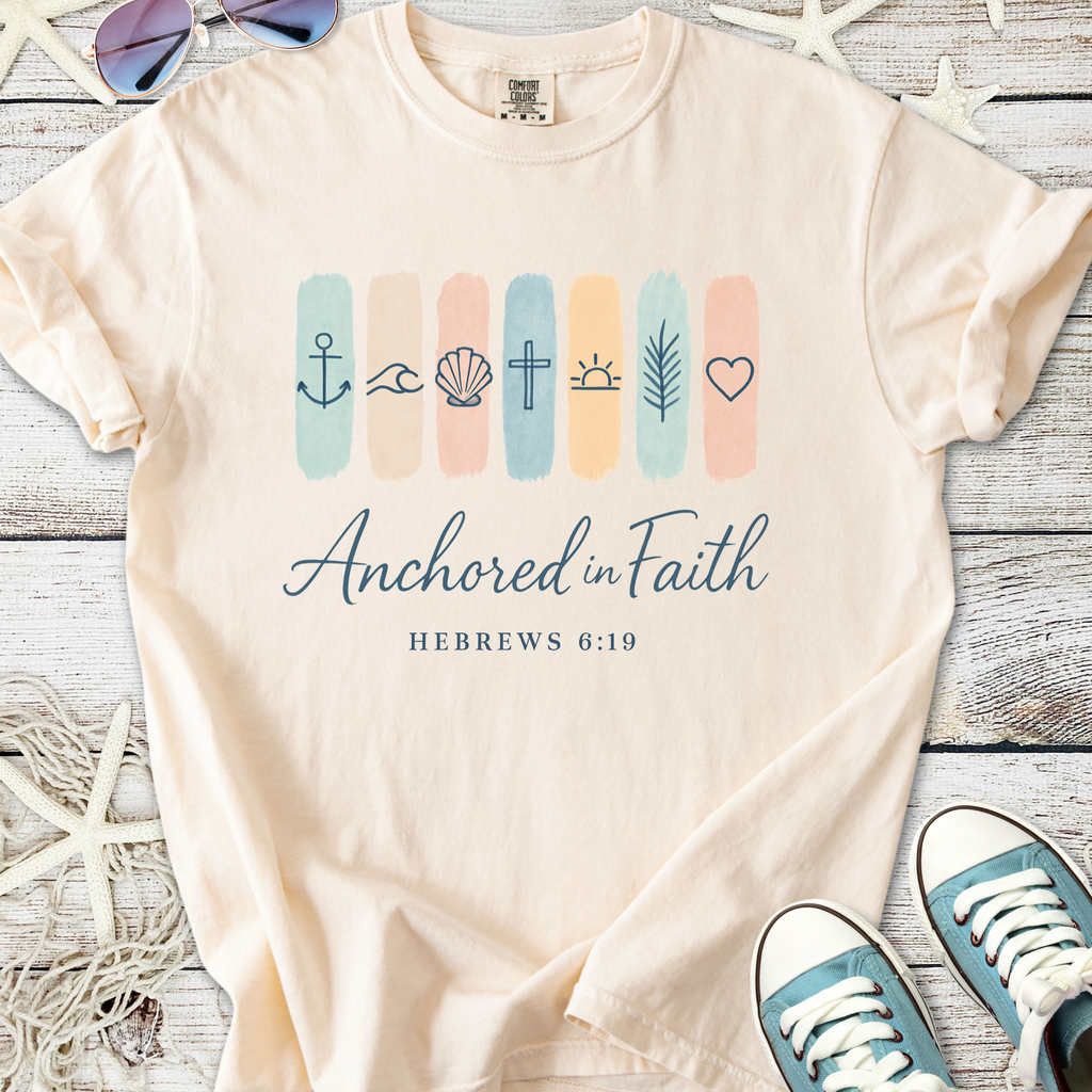 Beige t-shirt with 'Anchored in Faith' design, featuring religious symbols and Hebrews 6:19 text.
