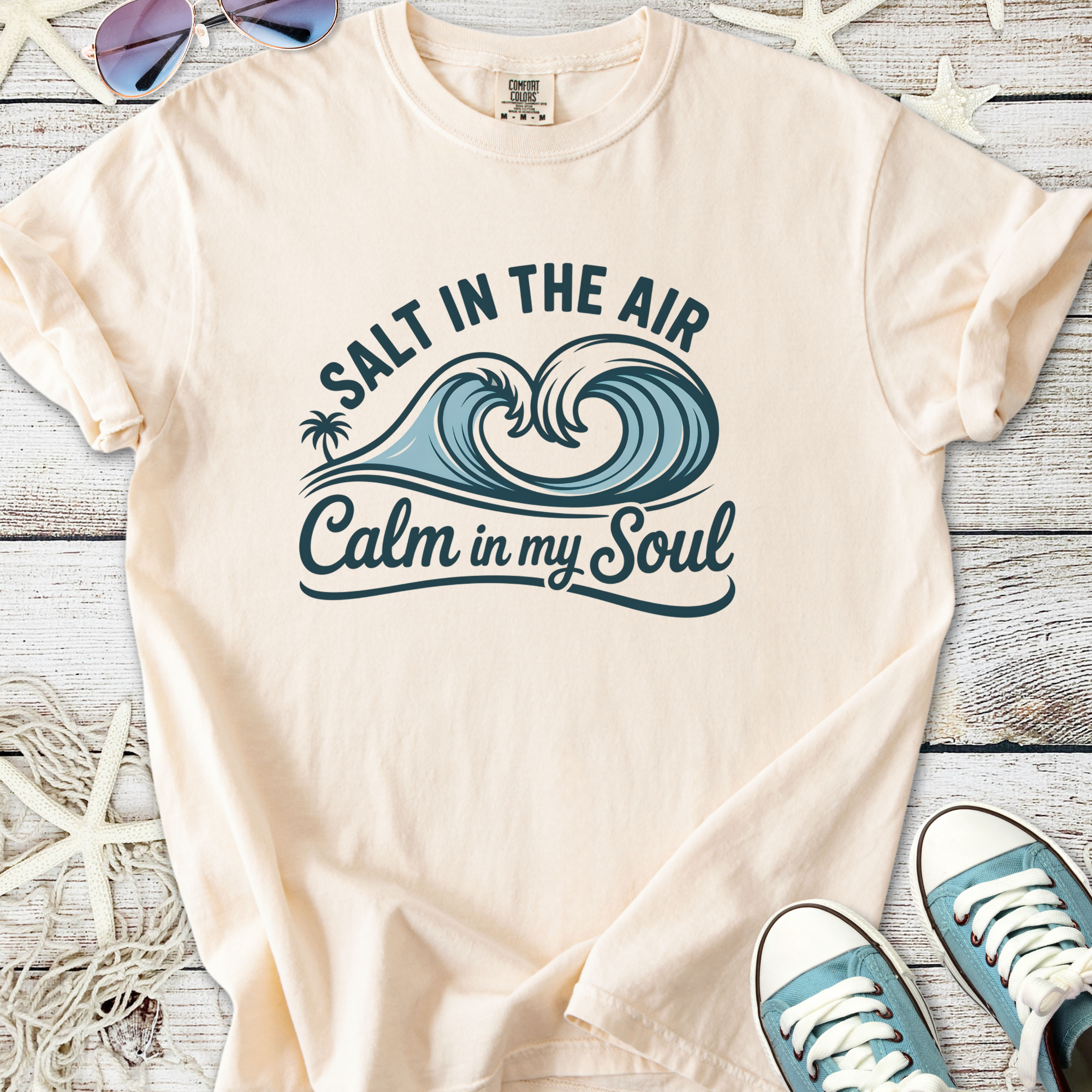 Light peach t-shirt with ocean waves graphic reading 'Salt in the Air, Calm in my Soul'
