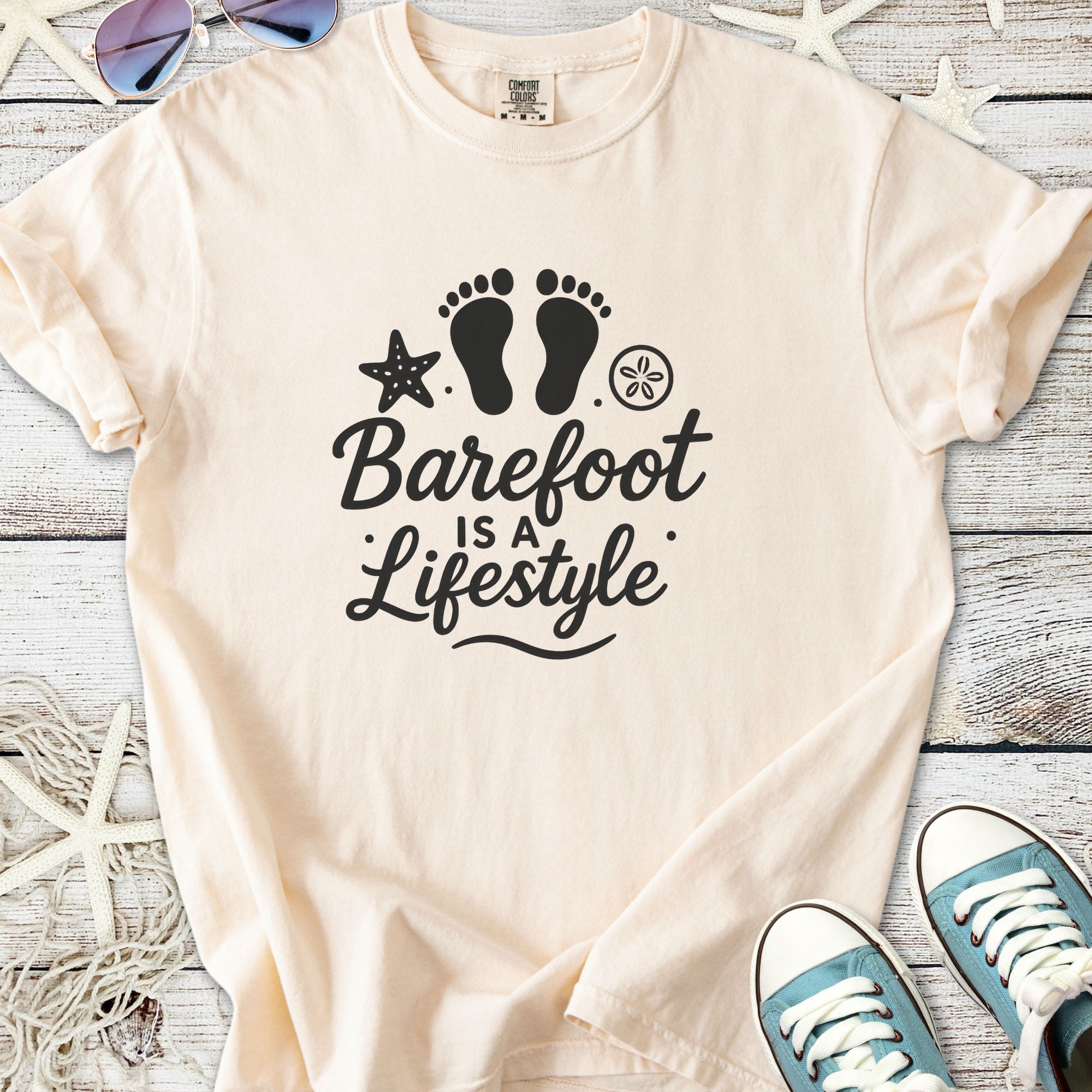 Beige graphic tee with 'Barefoot is a Lifestyle' print, perfect for casual summer wear.
