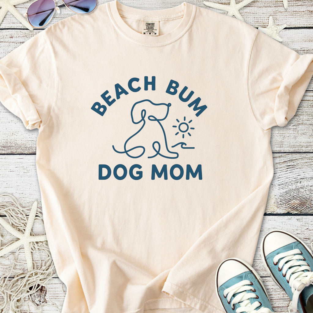 Peach beach-themed t-shirt for dog moms with 'Beach Bum Dog Mom' graphic, made from soft cotton.