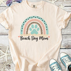 Cream t-shirt for dog lovers with 'Beach Dog Mom' graphic and colorful rainbow design