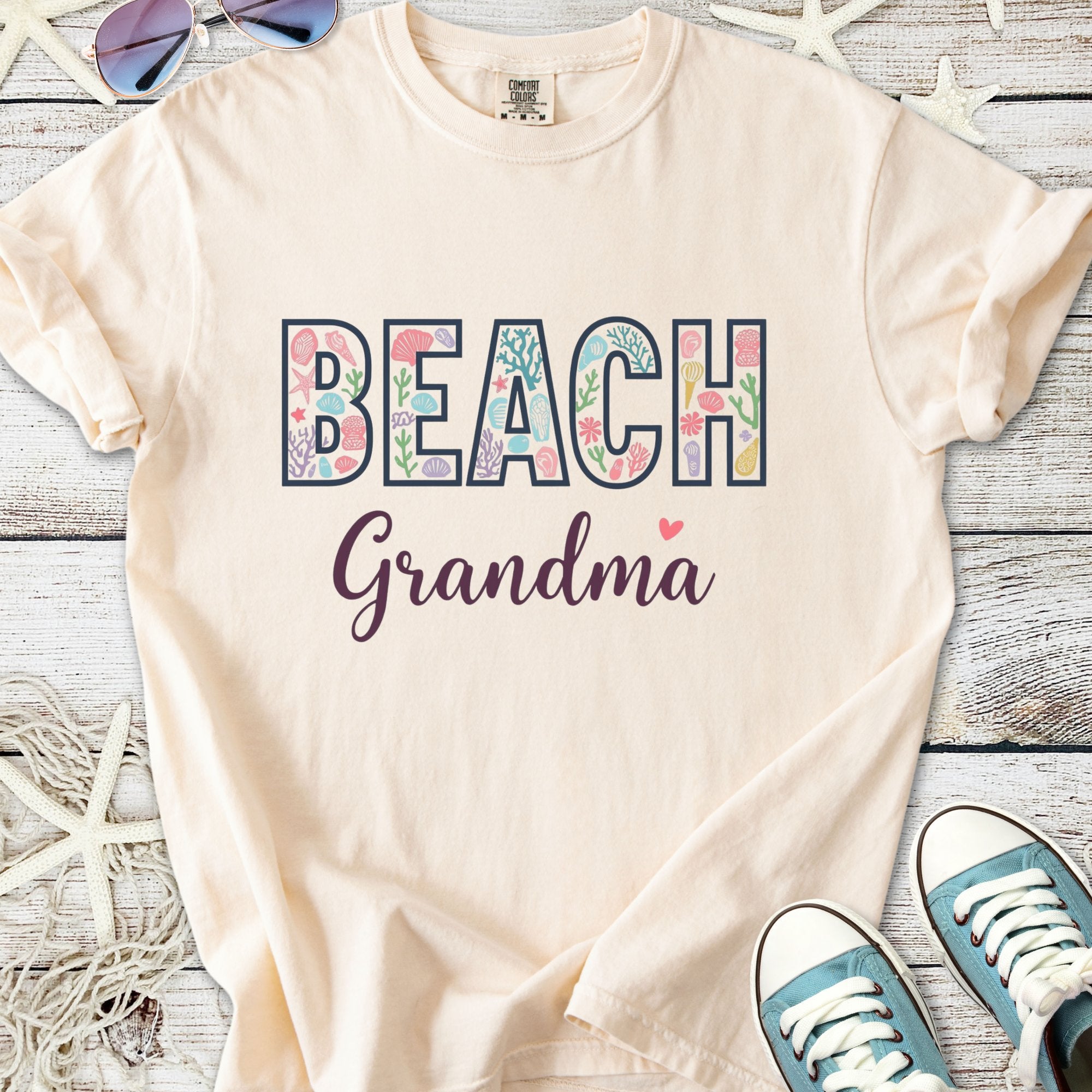 Cream t-shirt with 'BEACH Grandma' graphic, floral design, comfortable cotton fabric, perfect for summer outings.