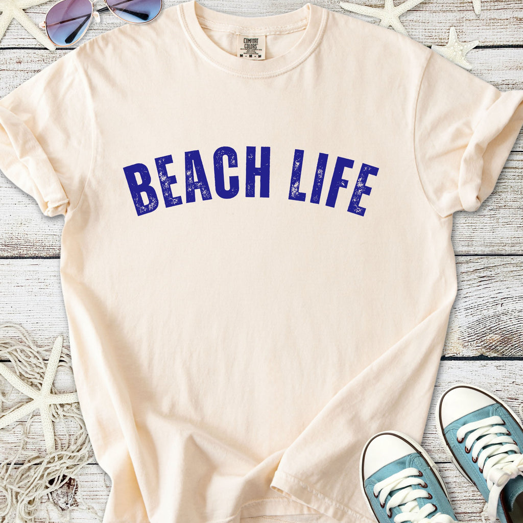 Cream cotton t-shirt with 'BEACH LIFE' graphic in blue, perfect for summer wear.