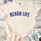 Cream cotton t-shirt with 'BEACH LIFE' graphic in blue, perfect for summer wear.