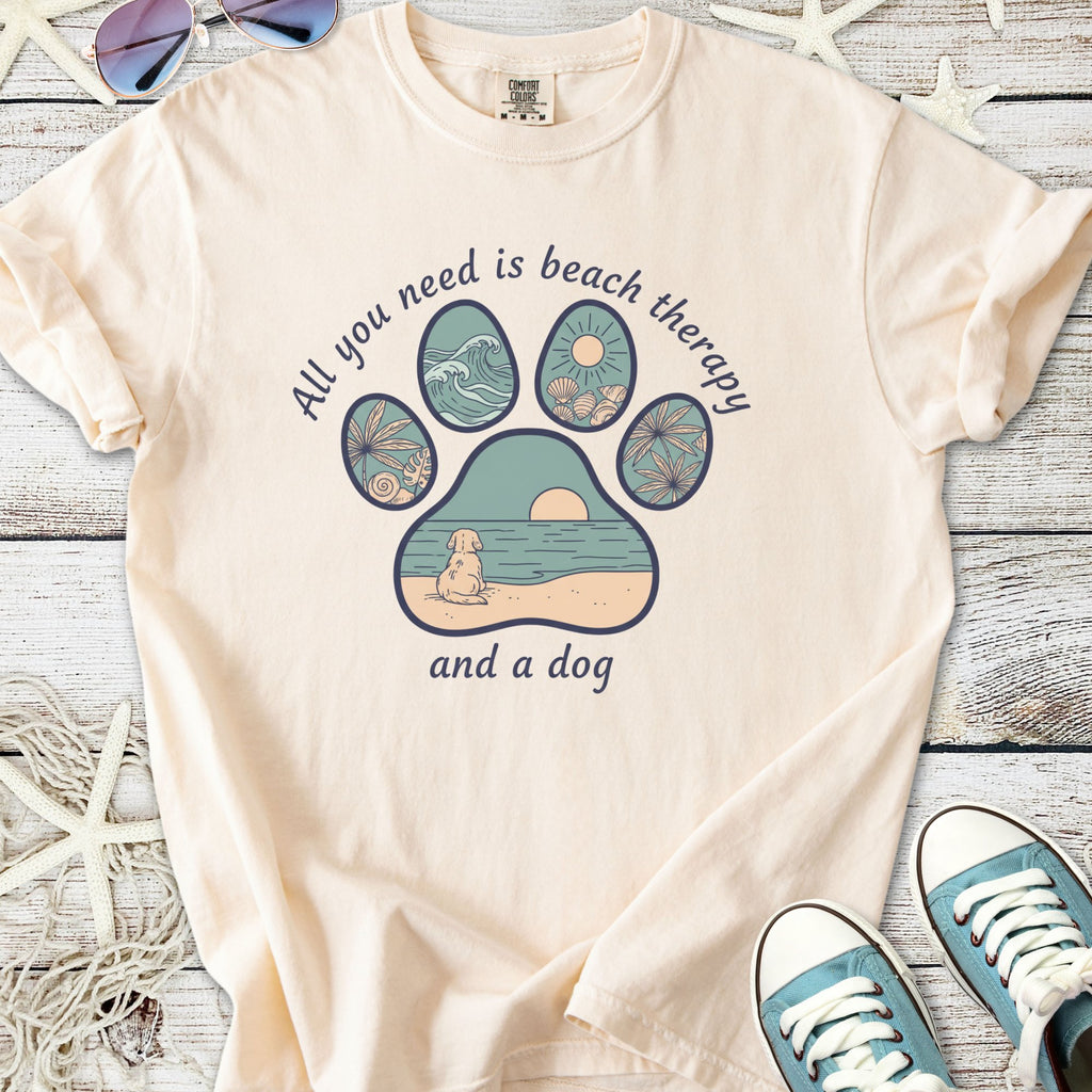 Light peach t-shirt with beach-themed paw print graphic, featuring a dog and ocean elements.