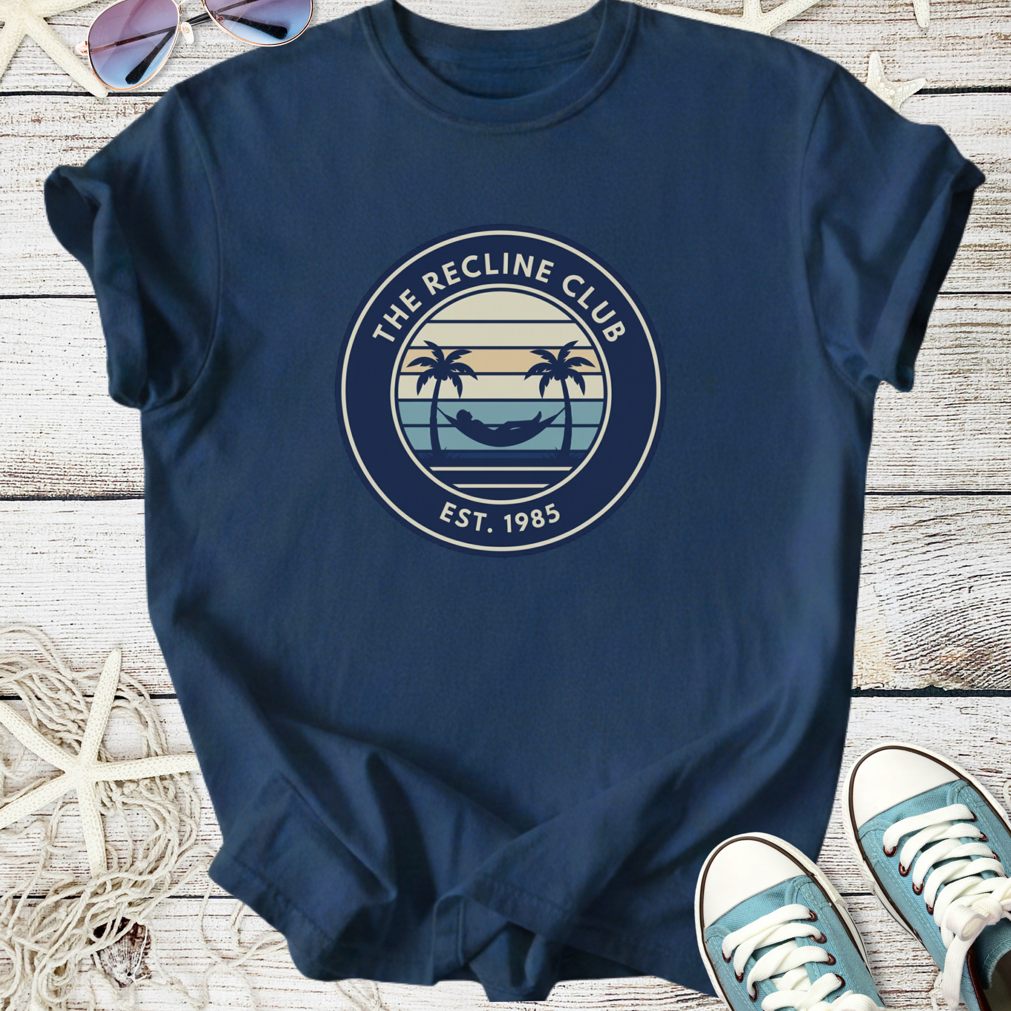 Men's navy blue tee shirt featuring 'The Recline Club' logo with palm trees and hammock, cotton fabric.