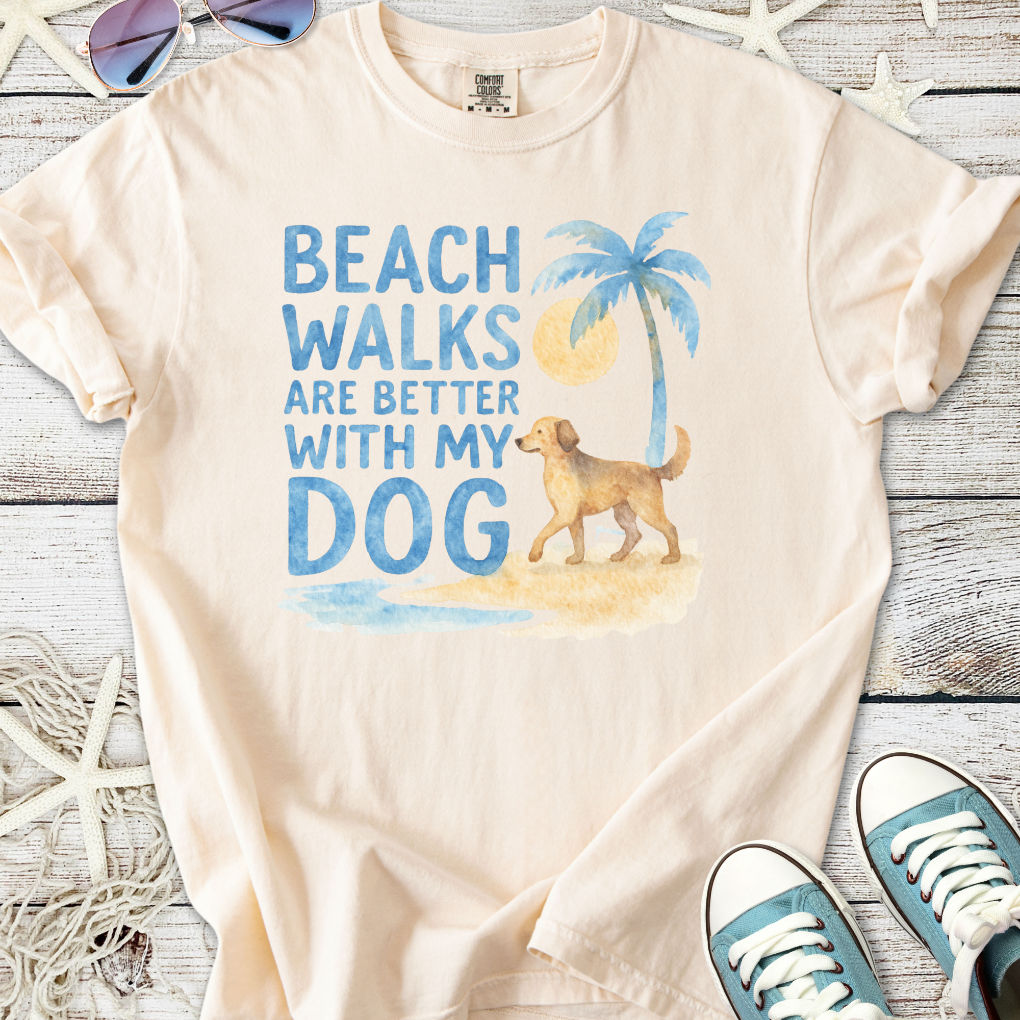 Peach t-shirt with 'Beach walks are better with my dog' graphic, featuring a golden retriever and palm tree.