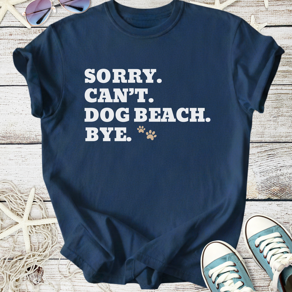 Navy blue t-shirt with humorous text 'Sorry. Can't. Dog Beach. Bye.' in white. Perfect for dog lovers.