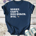 Navy blue t-shirt with humorous text 'Sorry. Can't. Dog Beach. Bye.' in white. Perfect for dog lovers.