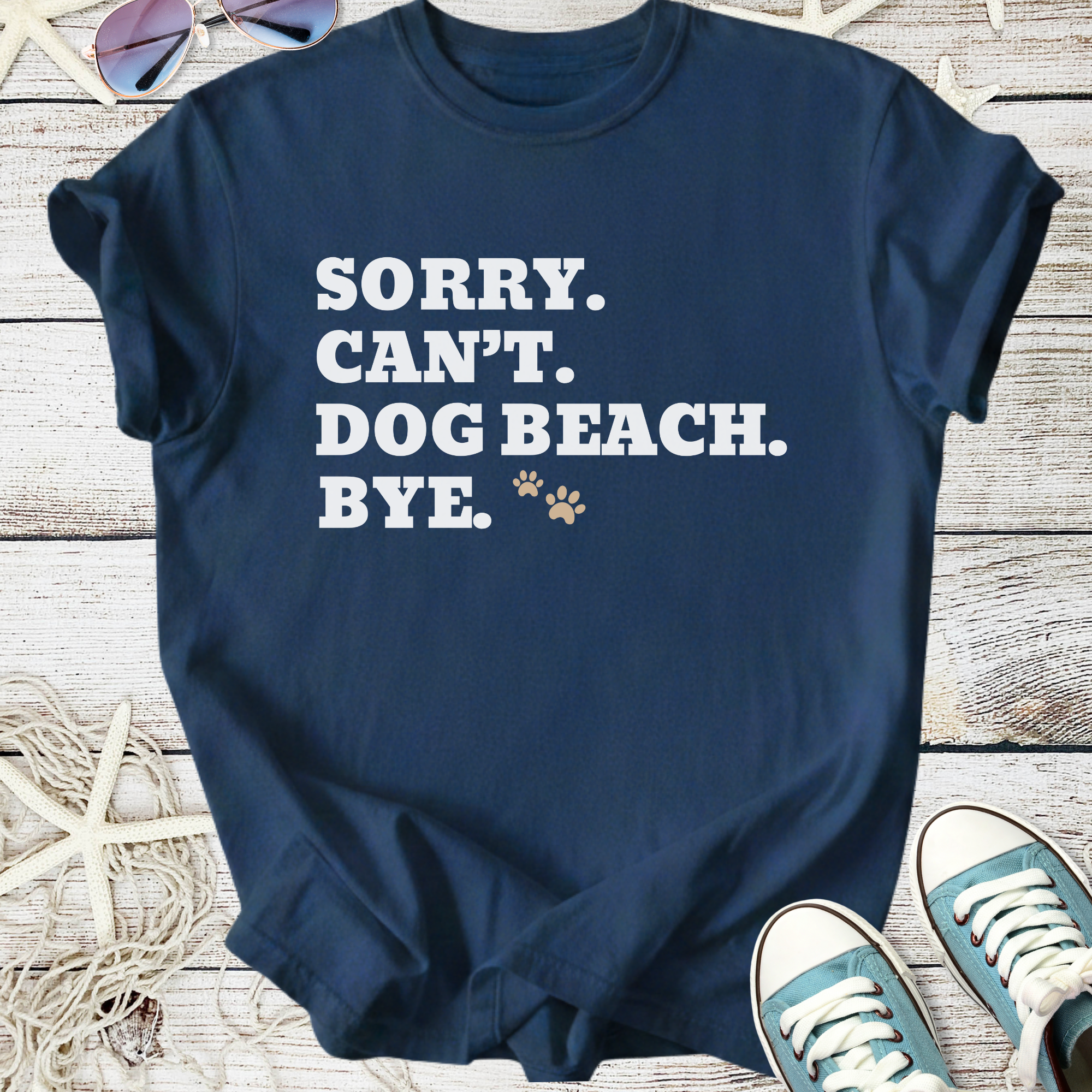 Navy blue t-shirt with humorous text 'Sorry. Can't. Dog Beach. Bye.' in white. Perfect for dog lovers.
