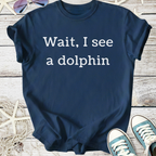 Navy blue graphic t-shirt with 'Wait, I see a dolphin' text, casual style, perfect for beachwear.