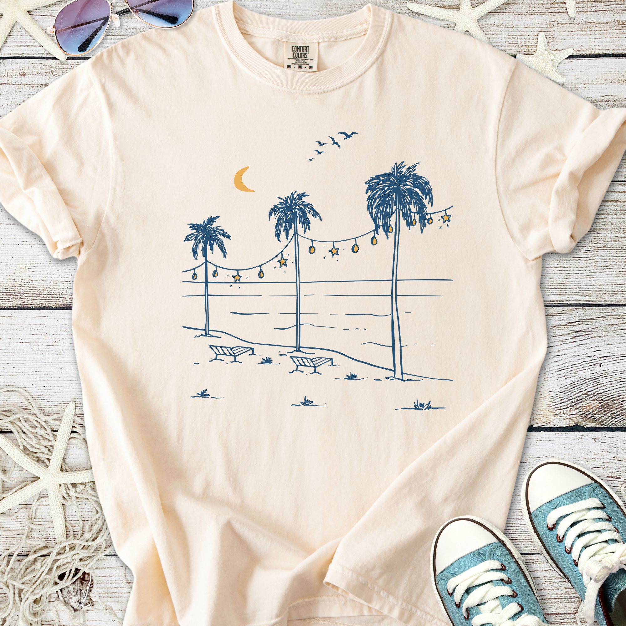 Light peach t-shirt with beach palm tree graphic and moon, made of soft cotton for summer wear.