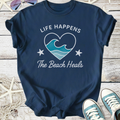 Navy blue t-shirt with 'Life Happens The Beach Heals' graphic and wave design, perfect for beach lovers.