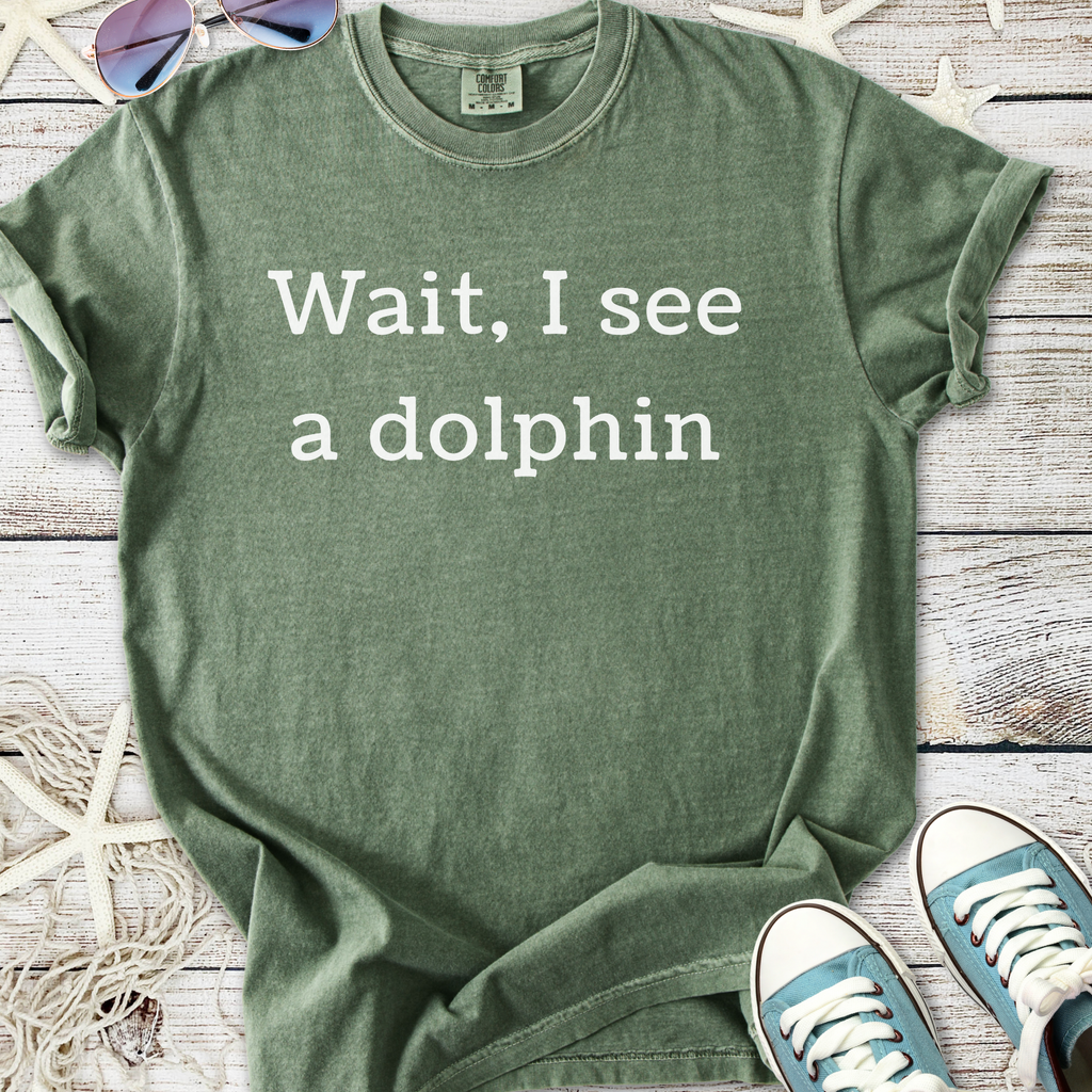 Green cotton t-shirt with 'Wait, I see a dolphin' print, perfect for casual summer wear.
