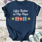 Navy blue graphic tee featuring "Life's Better in Flip Flops" with colorful flip flop designs and sun motifs.