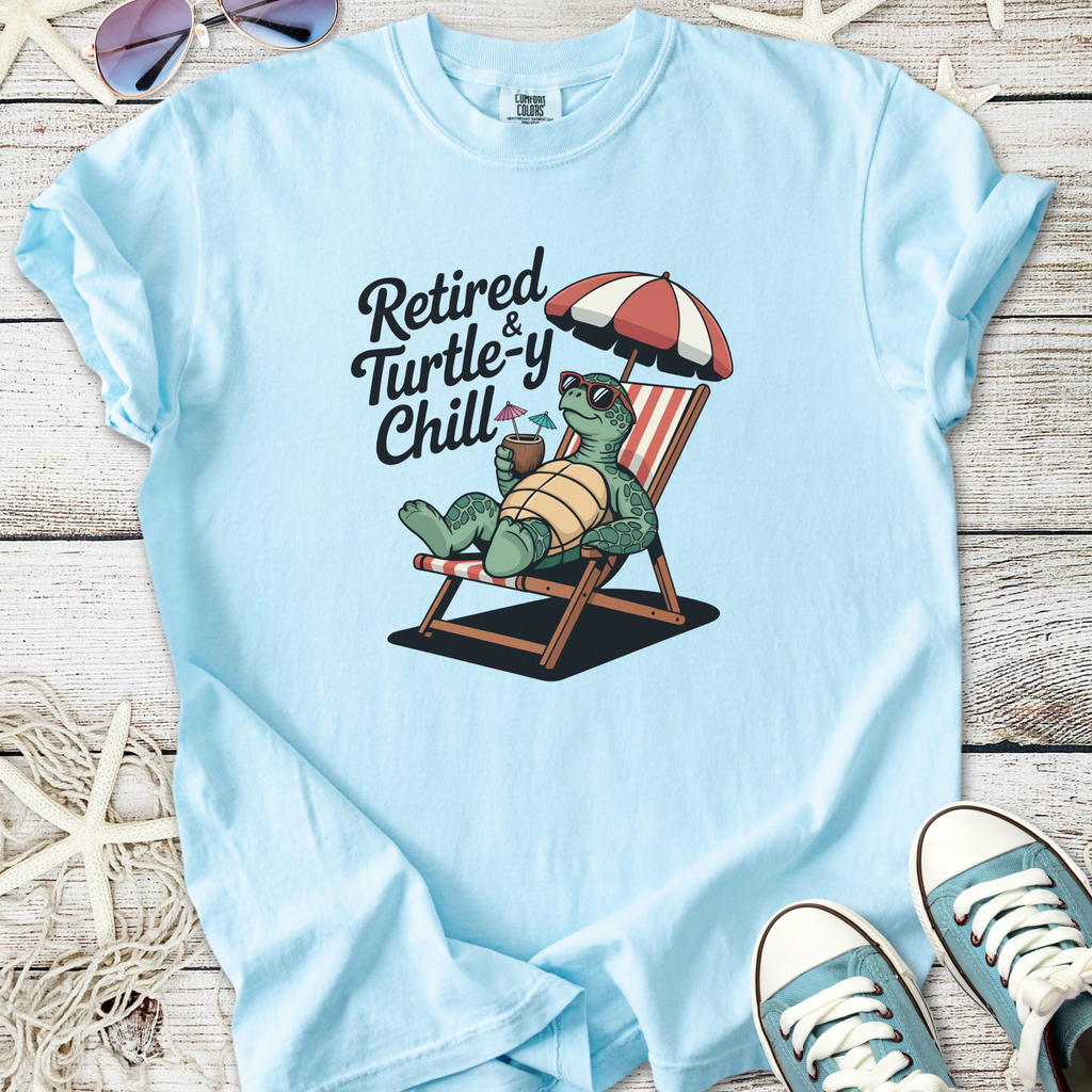 Light blue t-shirt featuring a turtle graphic with 'Retired & Turtle-y Chill' slogan, perfect for relaxing.