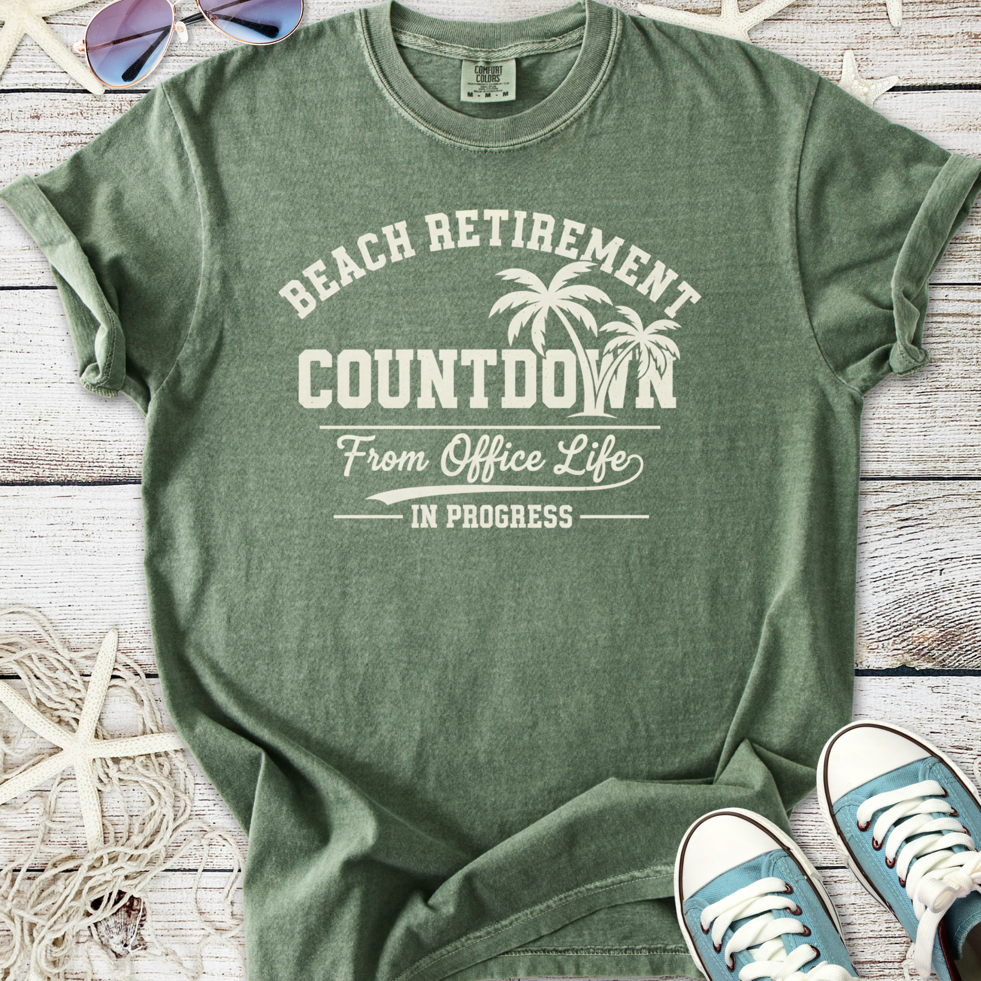 Green cotton t-shirt with 'Beach Retirement Countdown' graphic, perfect for relaxed beach vibes.