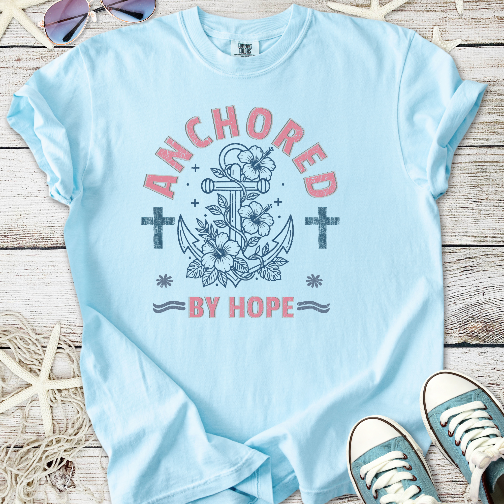 Light blue t-shirt with 'Anchored by Hope' graphic, floral anchor design, perfect for casual wear.