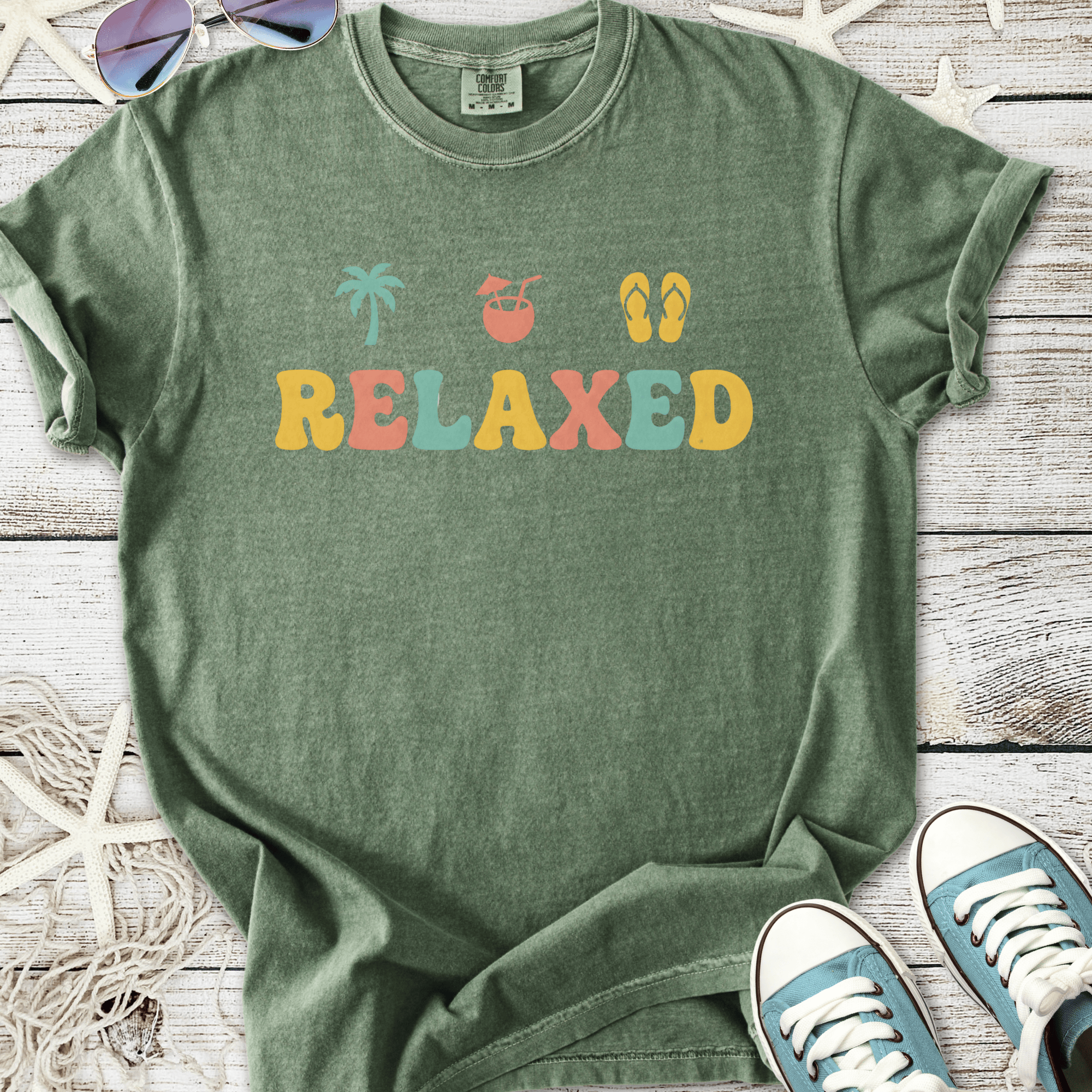 Green relaxed graphic t-shirt with palm tree, drink, and flip-flop designs, perfect for casual summer wear.