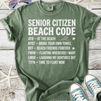 Green cotton t-shirt with 'Senior Citizen Beach Code' graphic, featuring fun beach phrases and casual style.