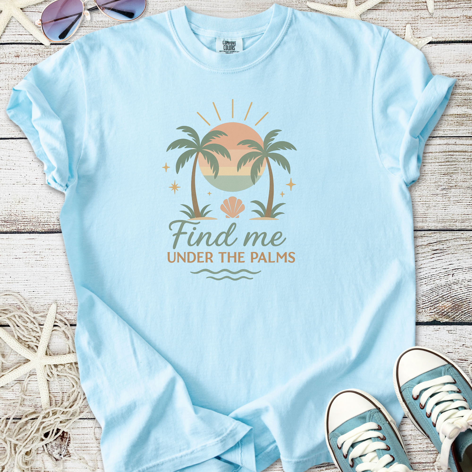 Light blue t-shirt featuring palm tree design with the text 'Find me Under the Palms'