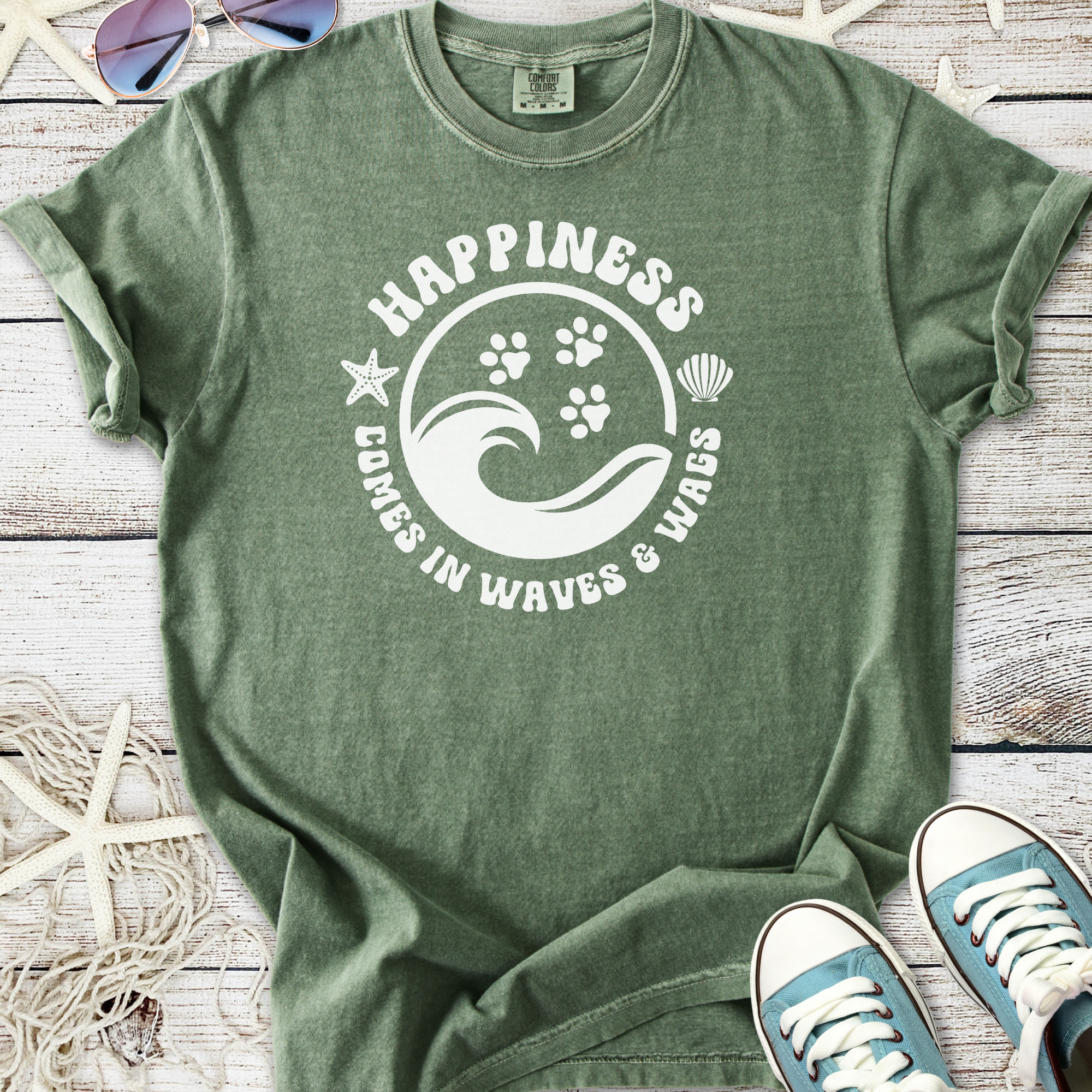 Olive green t-shirt with 'Happiness Comes in Waves & Wags' graphic, featuring ocean and paw print design.