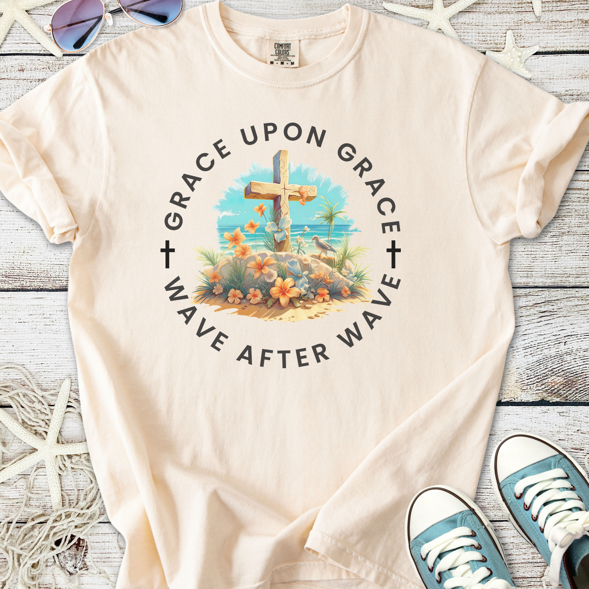 Beige graphic t-shirt featuring a floral cross design, ‘Grace Upon Grace’ text, perfect for casual summer wear.