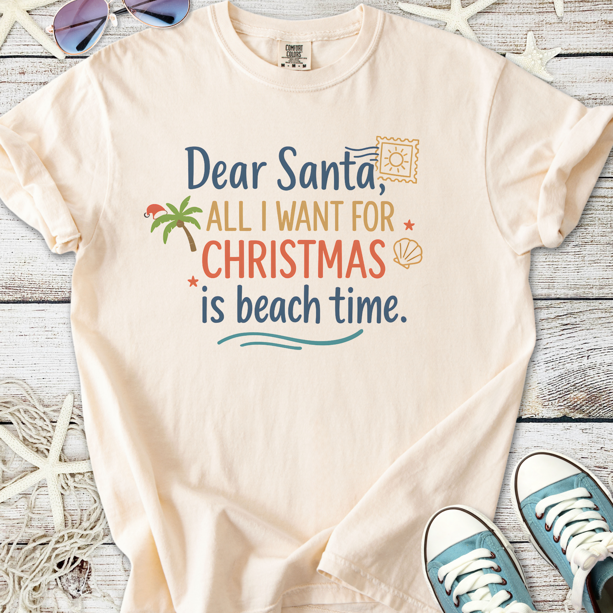Beige Christmas t-shirt with beach-themed graphic and text 'Dear Santa, all I want for Christmas is beach time'.
