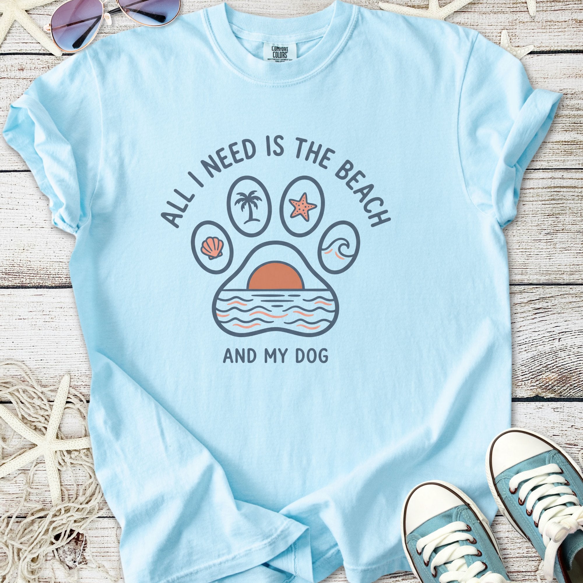 Light blue t-shirt with 'All I Need Is The Beach and My Dog' graphic, featuring beach-themed designs.