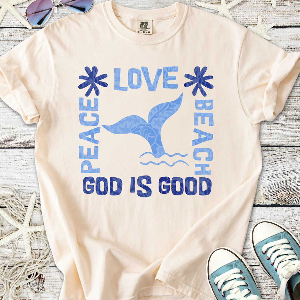 Cream beach-themed t-shirt with blue graphics: 'Peace, Love, Beach, God is Good' and a whale tail design.