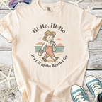 Cream beach-themed t-shirt with child graphic, cotton material, perfect for summer outings.