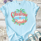 Light blue t-shirt featuring 'Christmas in Paradise' design with tropical leaves and beach graphic.