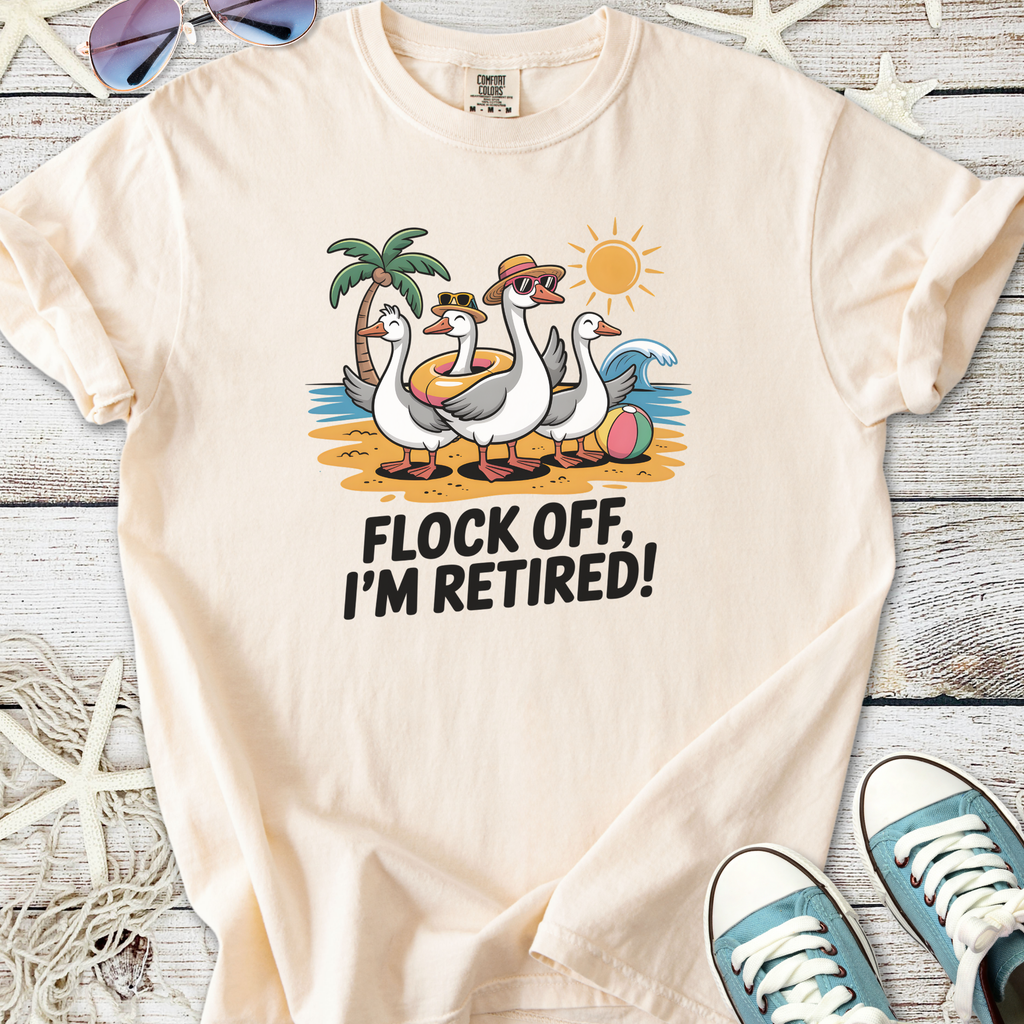 Cream t-shirt with quirky 'Flock Off, I'm Retired!' graphic featuring cartoon ducks at the beach.
