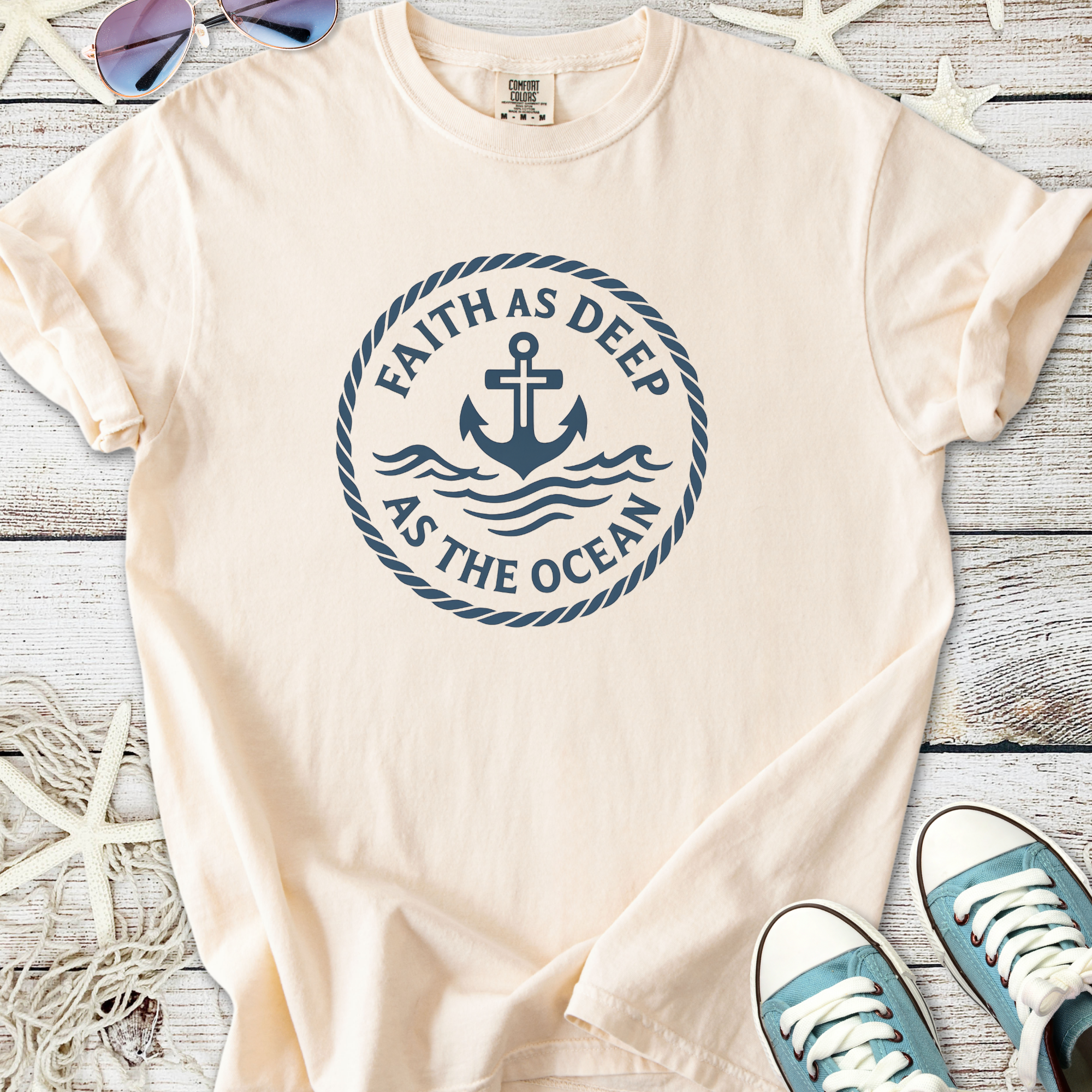 Cream-colored t-shirt featuring 'Faith as Deep as the Ocean' with anchor and waves design.