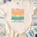 Beige graphic tee featuring sunrise design with text 'His Mercies Are New Every Morning'.