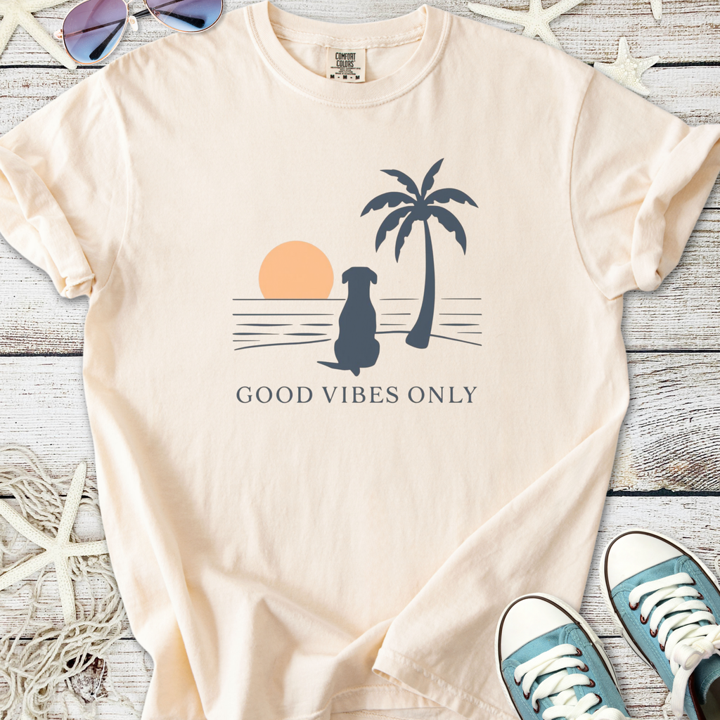 Peach graphic t-shirt featuring a dog, palm tree, sunset, and 'Good Vibes Only' text.