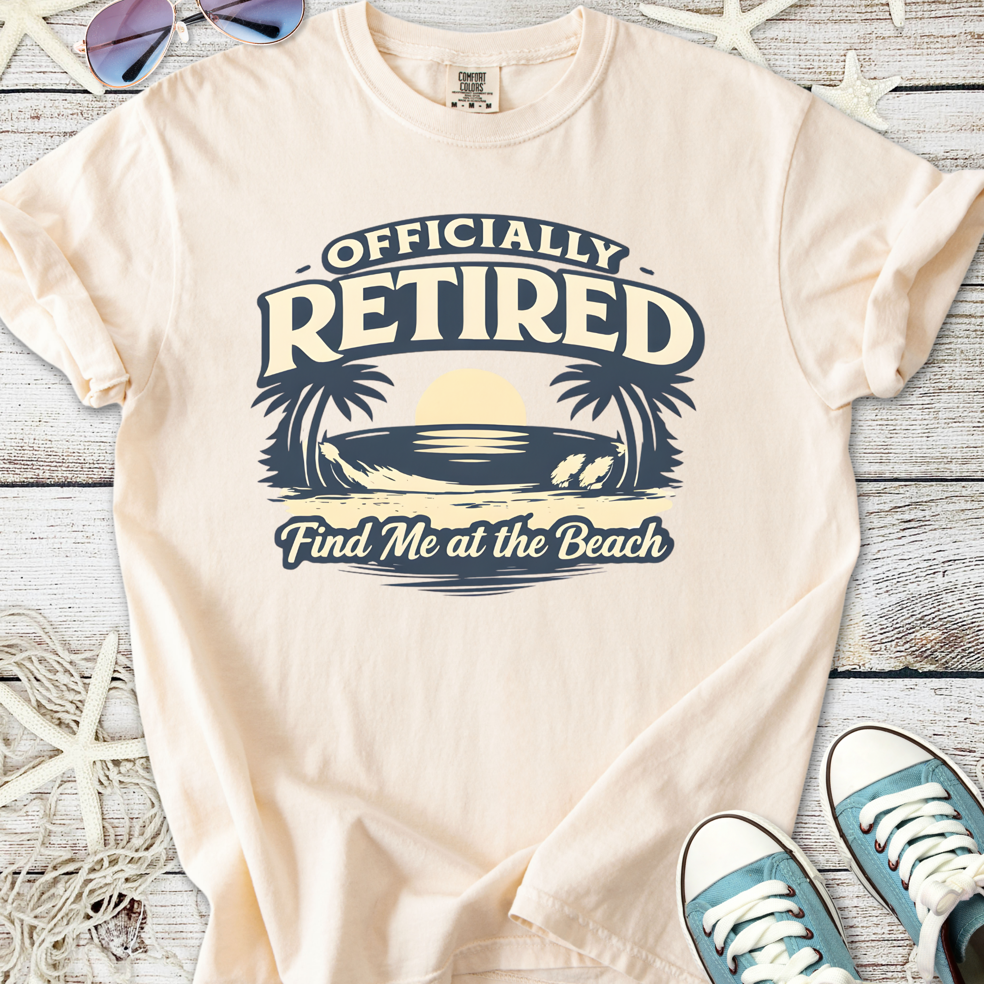 Peach-colored t-shirt with 'Officially Retired' graphic and beach theme, perfect for beach lovers.
